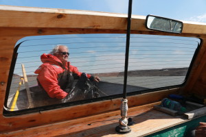 Dr. Rob Macdonald, Ph.D. sits at the bow of the boat as we make our way up the Coppermine River. (Photo credit: John Kelly)