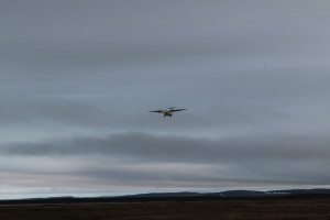 The first plane to land at Kugluktuk Airport in several days arrives. Heavy fog has prevented necessary groceries and other materials from arriving in this remote town. (Photo credit: John Kelly)