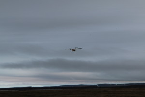 The first plane to land at Kugluktuk Airport in several days arrives. Heavy fog has prevented necessary groceries and other materials from arriving in this remote town. (Photo credit: John Kelly)