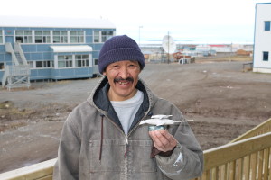 Roy, a resident of the small town of Kugluktuk, brings by a carving he made of two narwhals made out of soapstone. He has been carving for the past 30 years. (Photo credit: John Kelly)